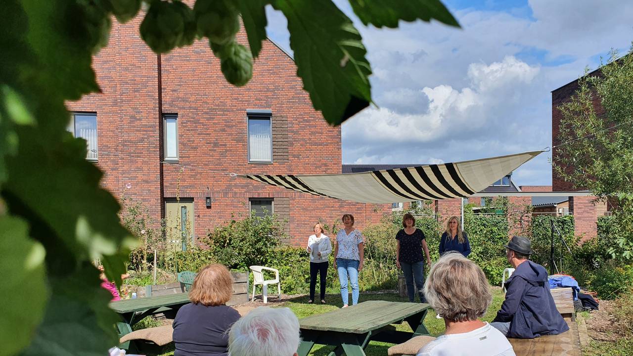 Bezoekers genieten van een optreden in de buitenlucht