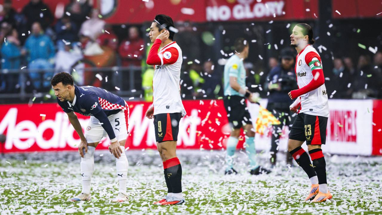 Spelers van PSV en Feyenoord tussen de vallende confetti (foto: ANP).