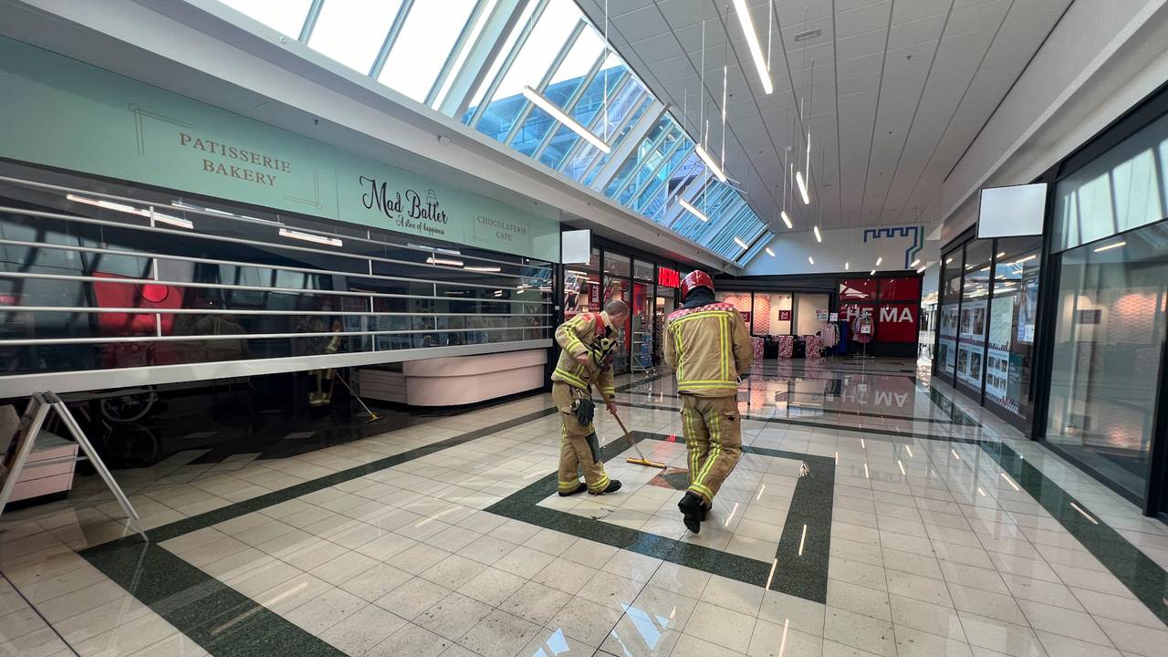 Brandweerlieden werken het water weg nadat sprinklerinstallaties in een winkelcentrum waren afgegaan (foto: SQ Vision).