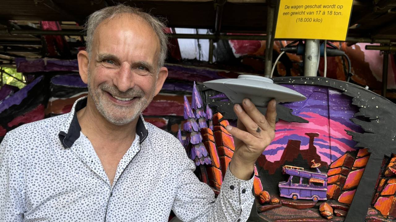 Johan Vlemmix met een miniatuurversie van de UFO, bij een maquette van de Corso-wagen in Zundert (foto: Niek de Bruijn)