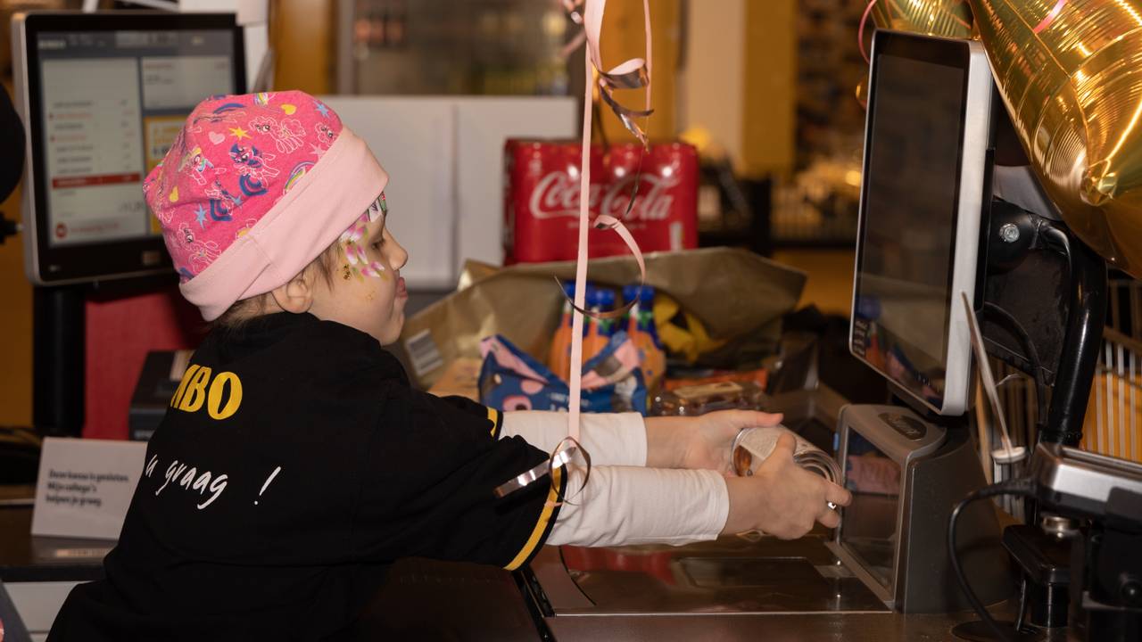 Nomi achter de kassa op haar wensdag in januari