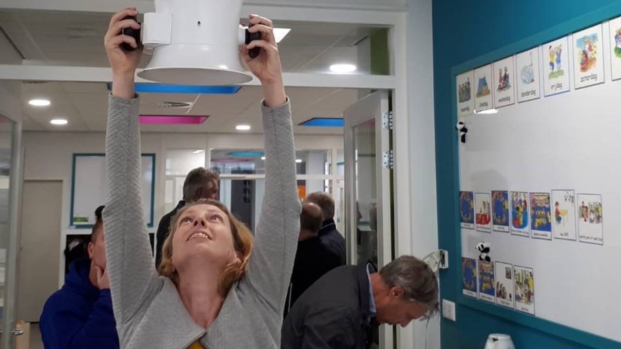 Froukje meet de hoeveelheid lucht door een ventilatierooster in een school. (Foto: Froukje van Dijken)