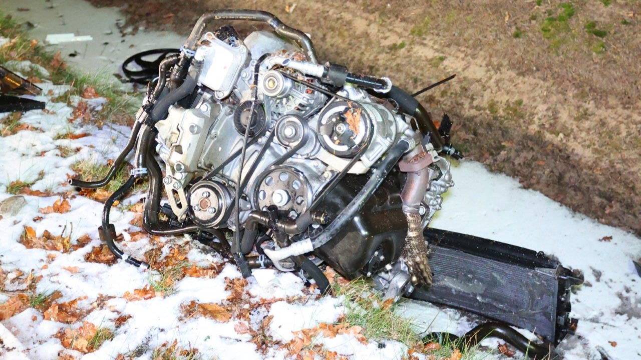 De accu en het motorblok schoten na de botsing met de boom uit de auto en kwamen op de weg en half in de sloot terecht (foto: Bart Meesters). 