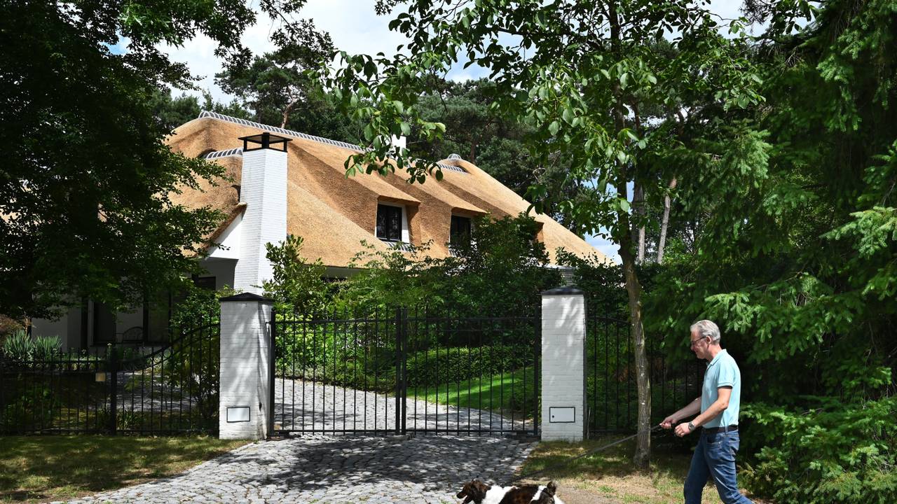 Een man laat zijn hond uit in een villawijk in Leende (foto: Peter Hilz / ANP).