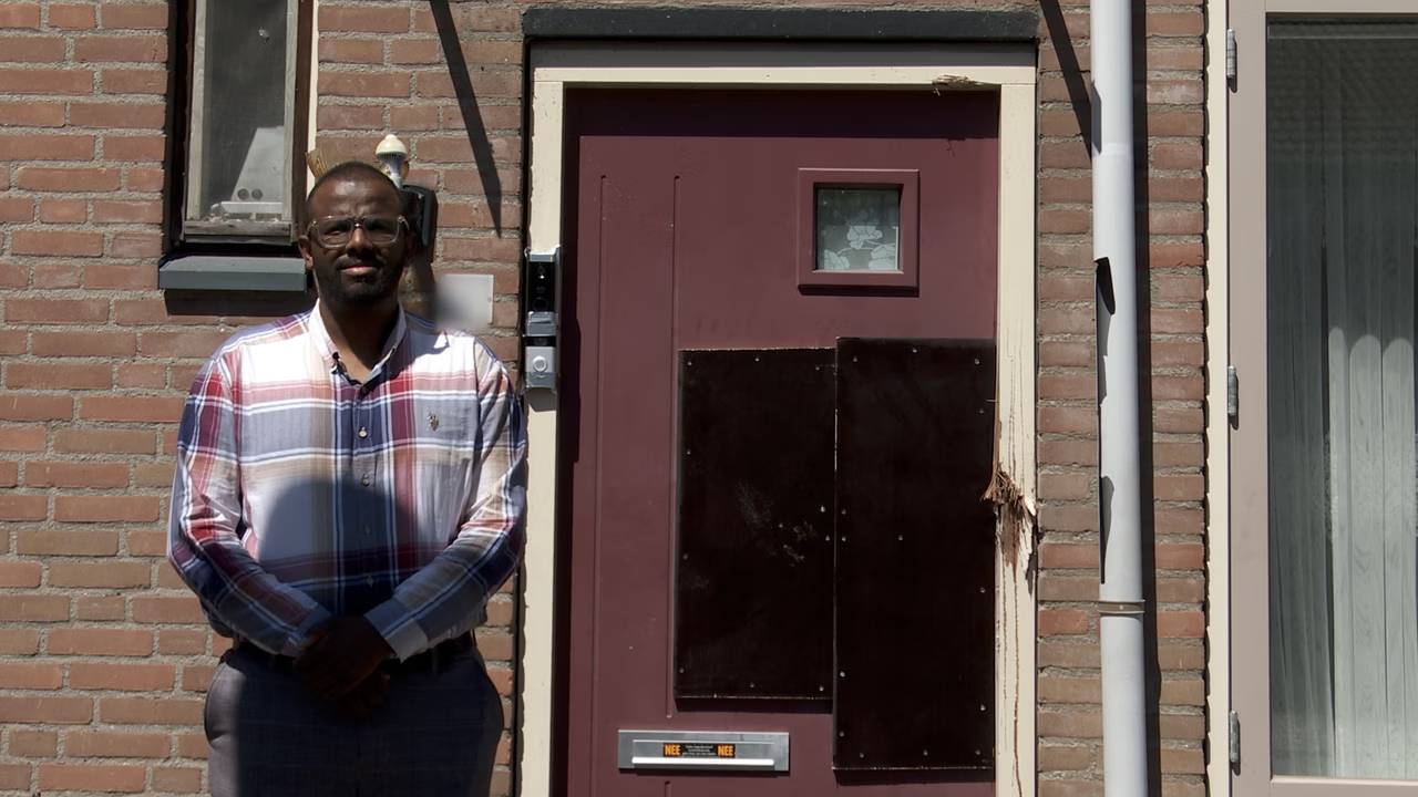 Abdulhali Hussen voor de beschadigde voordeur van zijn ouder (foto: Femke Brouwers/Dtv Nieuws).