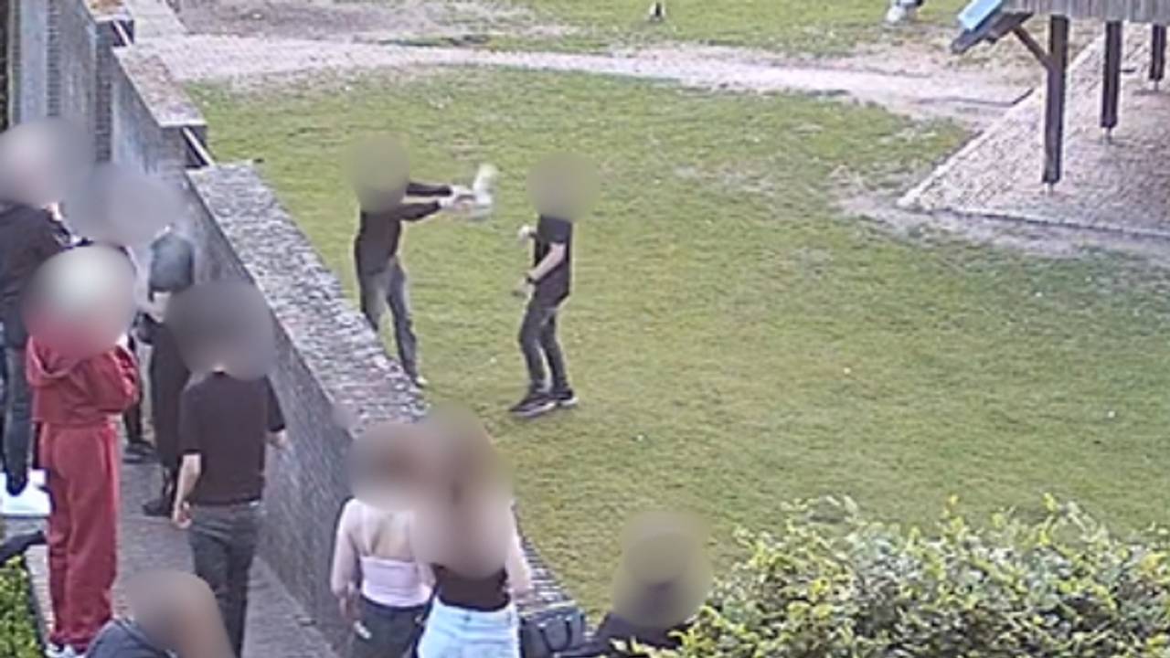 De jongens gooien de kippen naar elkaar, terwijl jongeren toekijken (foto: bewakingsbeelden privé).