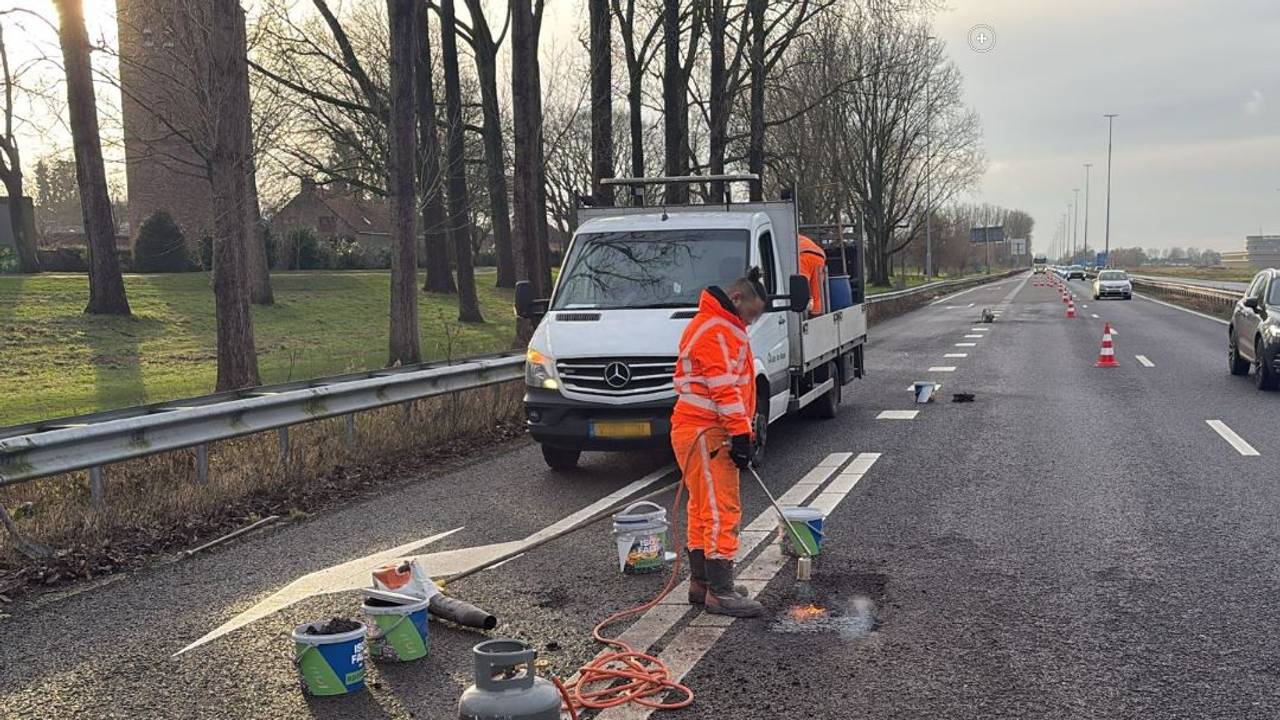 Wegwerkers herstellen het asfalt op de A59 (foto: Rijkswaterstaat).