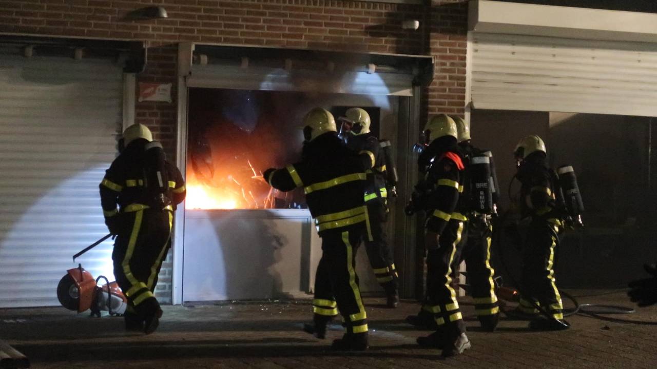 De politie breekt de deuren van de garageboxen open (foto: Perry Roovers/SQ Vision Mediaprodukties)