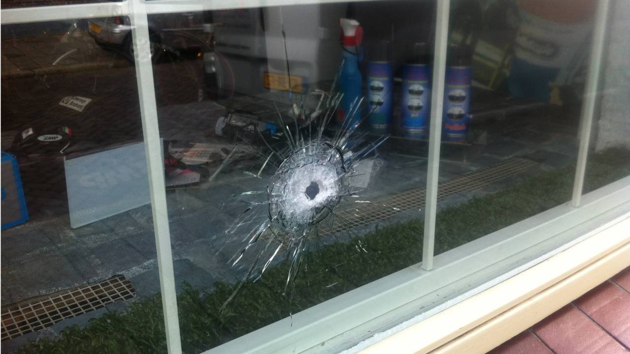 Kogelgat in ruit op de plek waar Damen werd neergeschoten. (foto: Pieter Bremer)