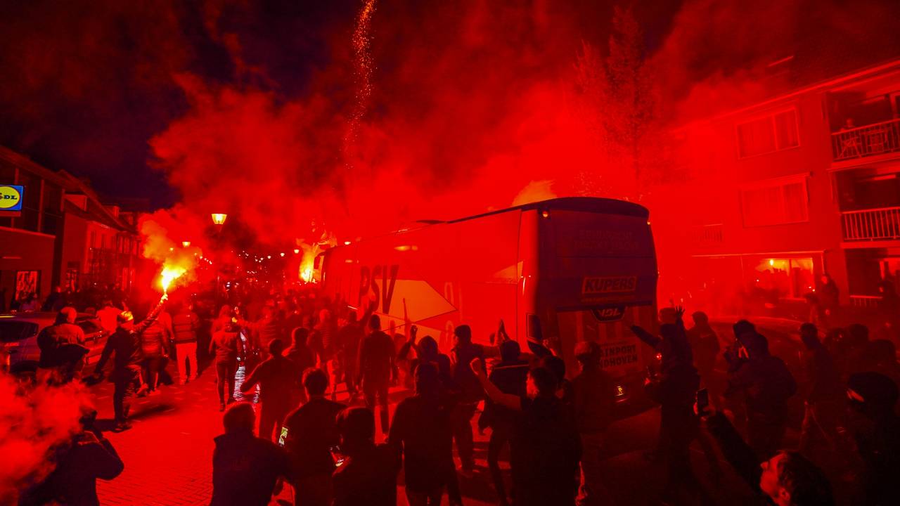 De spelersbus verdwijnt haast tussen de supporters en het vuurwerk (foto: SQ Vision)
