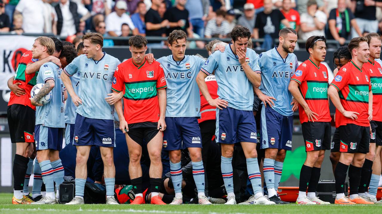 Spelers van NEC en Willem II staan om de geblesseerde Dirk Proper heen. (Foto: Broer van den Boom/Orange Pictures)