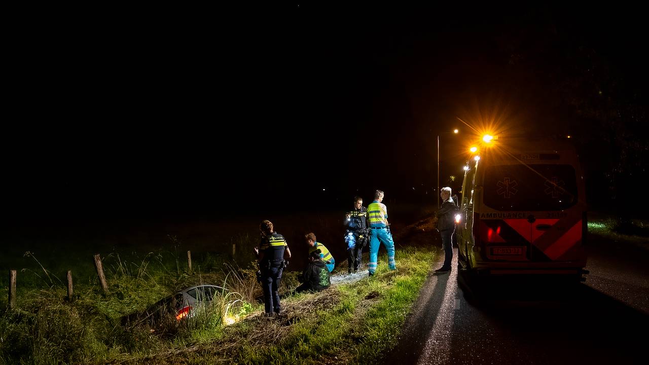 Agenten en ambulancemedewerkers bij de auto (foto: Iwan van Dun/SQ Vision).