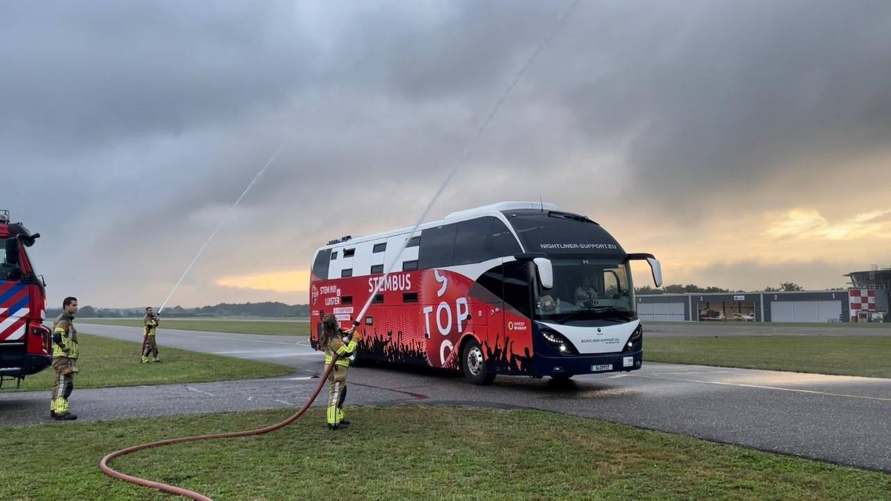 De bus onder het watersalut op Breda International Airport.