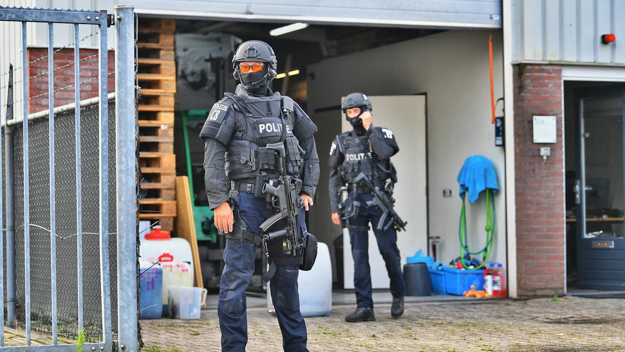 Het leegruimen van het drugslab in Maarheeze gebeurt onder zware bewaking (foto: Rico Vogels/SQ Vision).