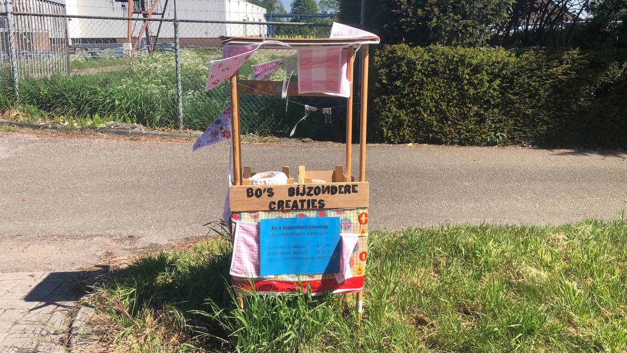 Het meisje verkoopt zelfgemaakte sieraden in haar kraampje.