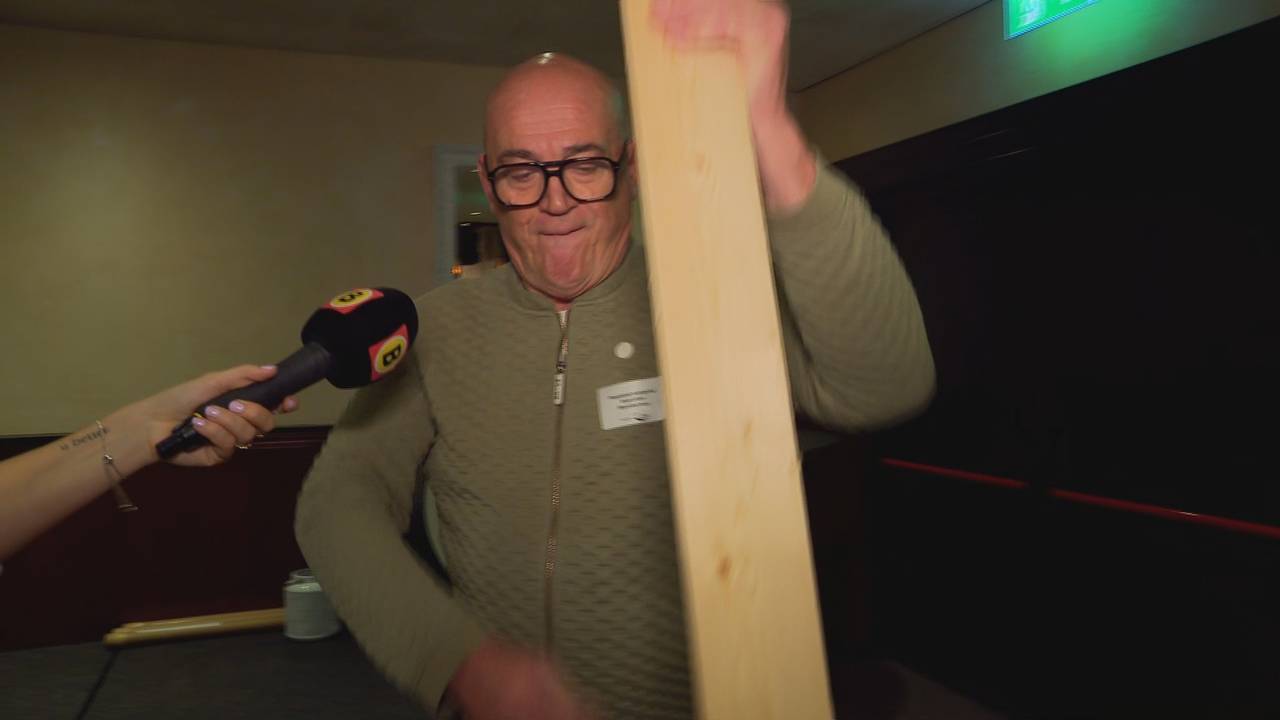 Met een lange plank stamt Rene de biljetten aan (beeld: Omroep Brabant).