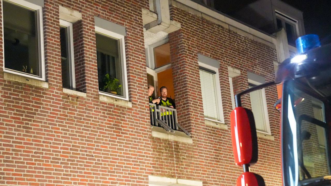 Het slot van de deur van het appartement in Deurne ging niet meer open, dus zaten de agenten vast (foto: Harrie Grijseels/SQ Vision).