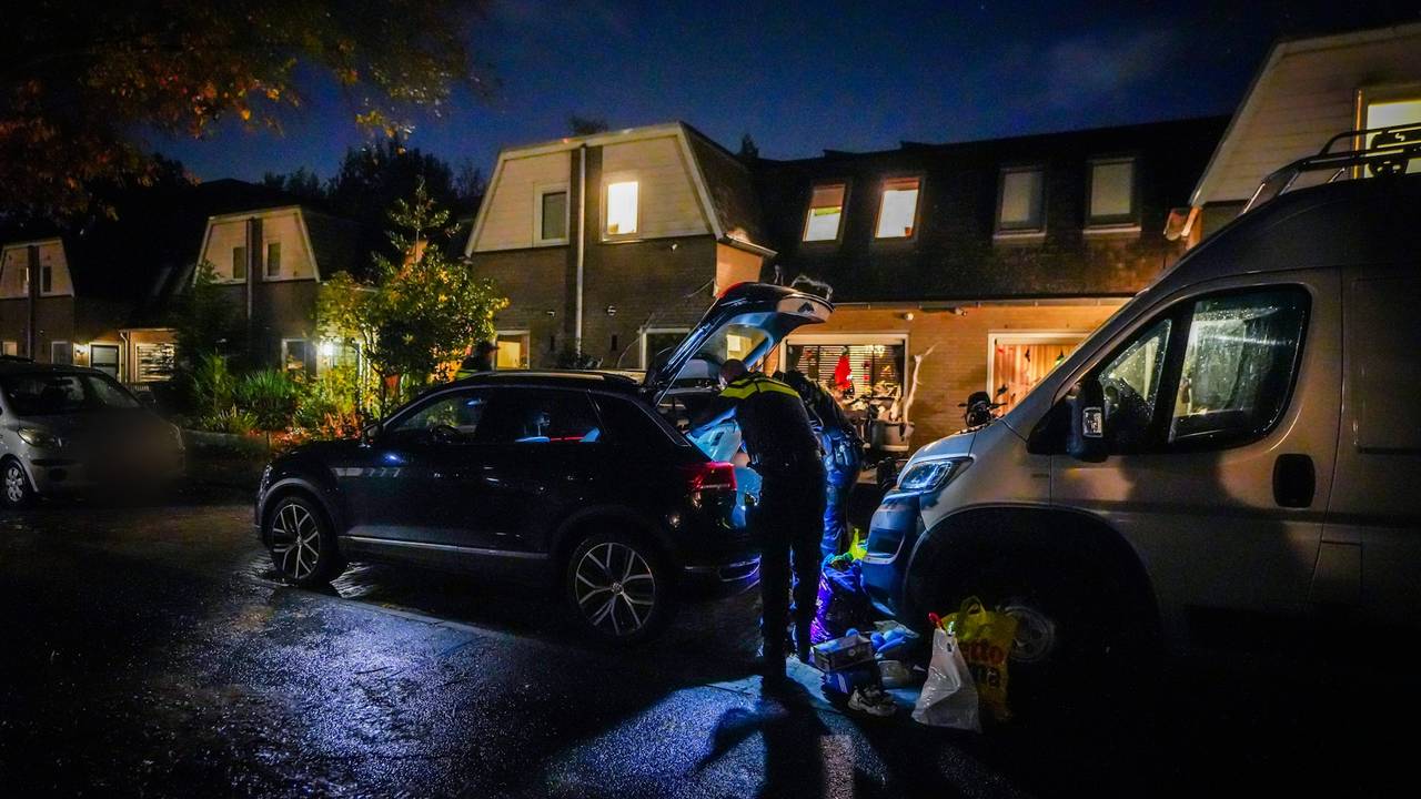 Agenten doorzoeken een huis en twee wagens (foto: SQ Vision).
