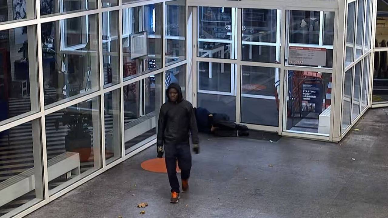 Nadat de man de stoeptegel gooide, liep hij weg (foto: politie Rotterdam).