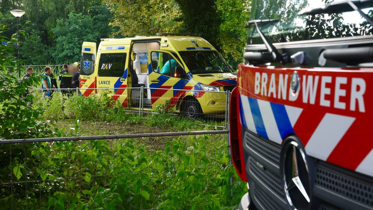 Een man die in Sint-Michielsgestel in de Dommel terecht was gekomen, werd door ambulancemedewerkers en de politie opgevangen (foto: Sander van Gils/SQ Vision).