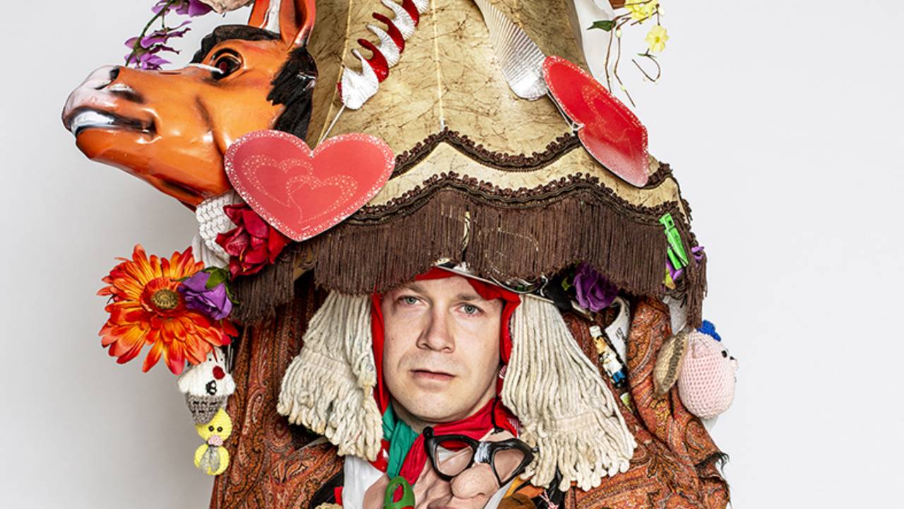 Grote mannen, grote lampenkappen! Zelfs zo groot dat het bevestigd is met beugels om zijn borstkas. 