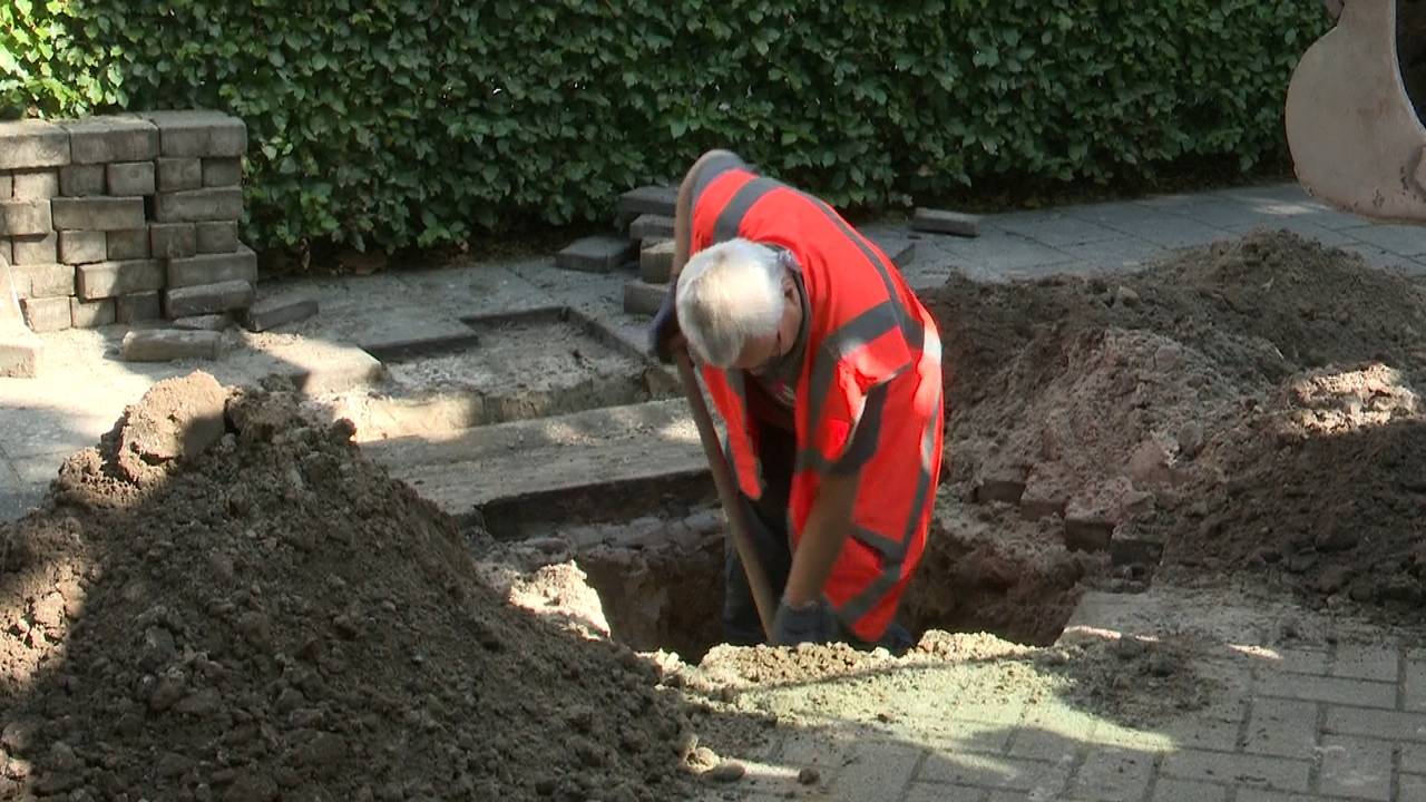 Een medewerker van Enexis zoekt naar een kapotte kabel