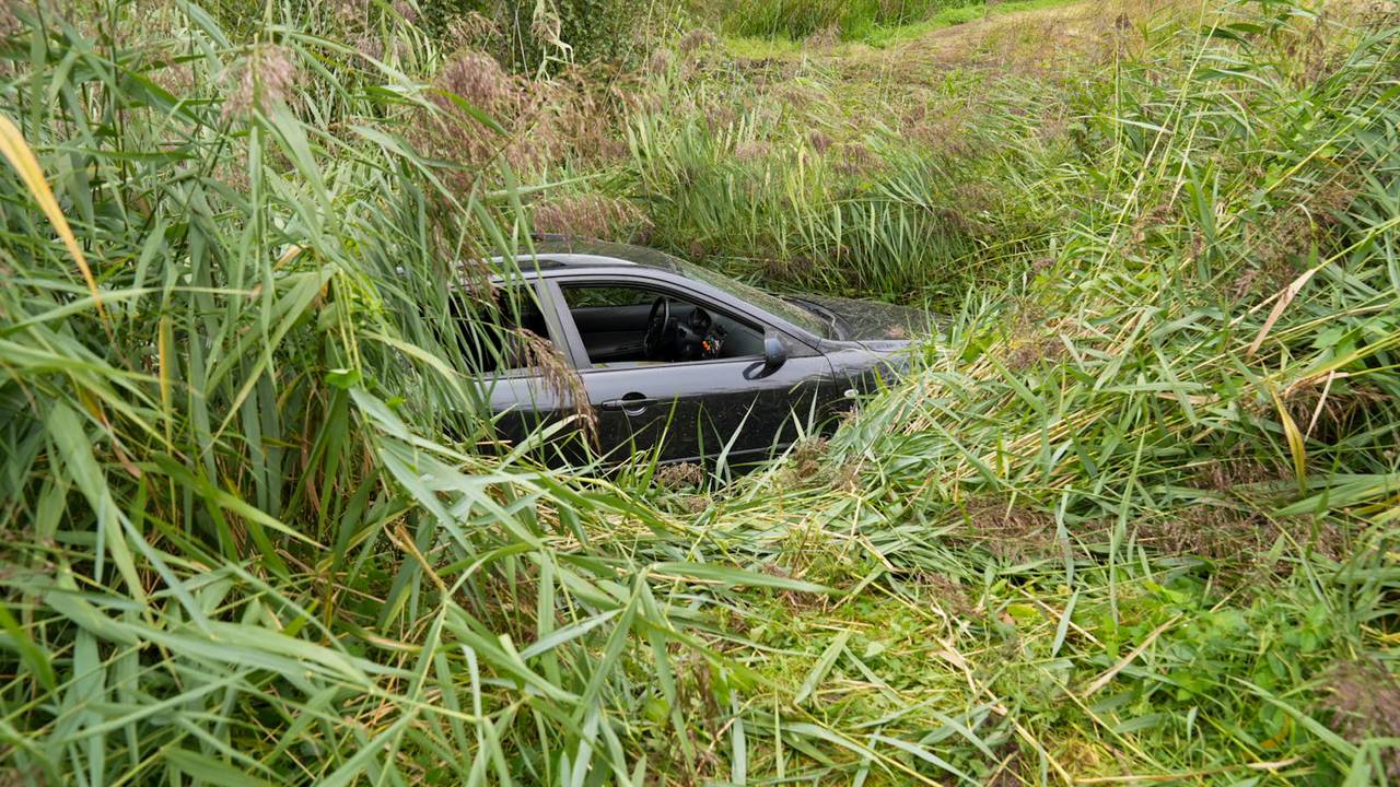 Hoe de auto in Aarle-Rixtel in een sloot kon belanden, wordt onderzocht (foto: Harrie Grijseels/SQ Vision).