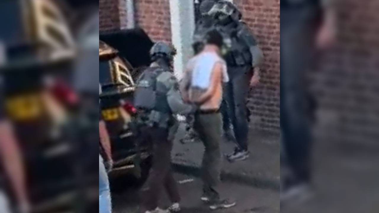De man wordt door het arrestatieteam uit het huis gehaald.
