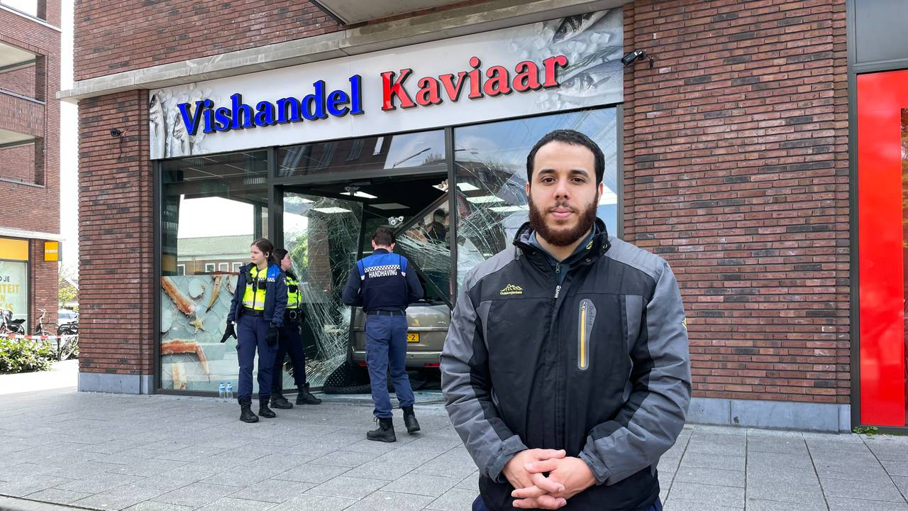 Mohamed El Yazidi voor de kapotte pui van zijn viswinkel (foto: Omroep Brabant).