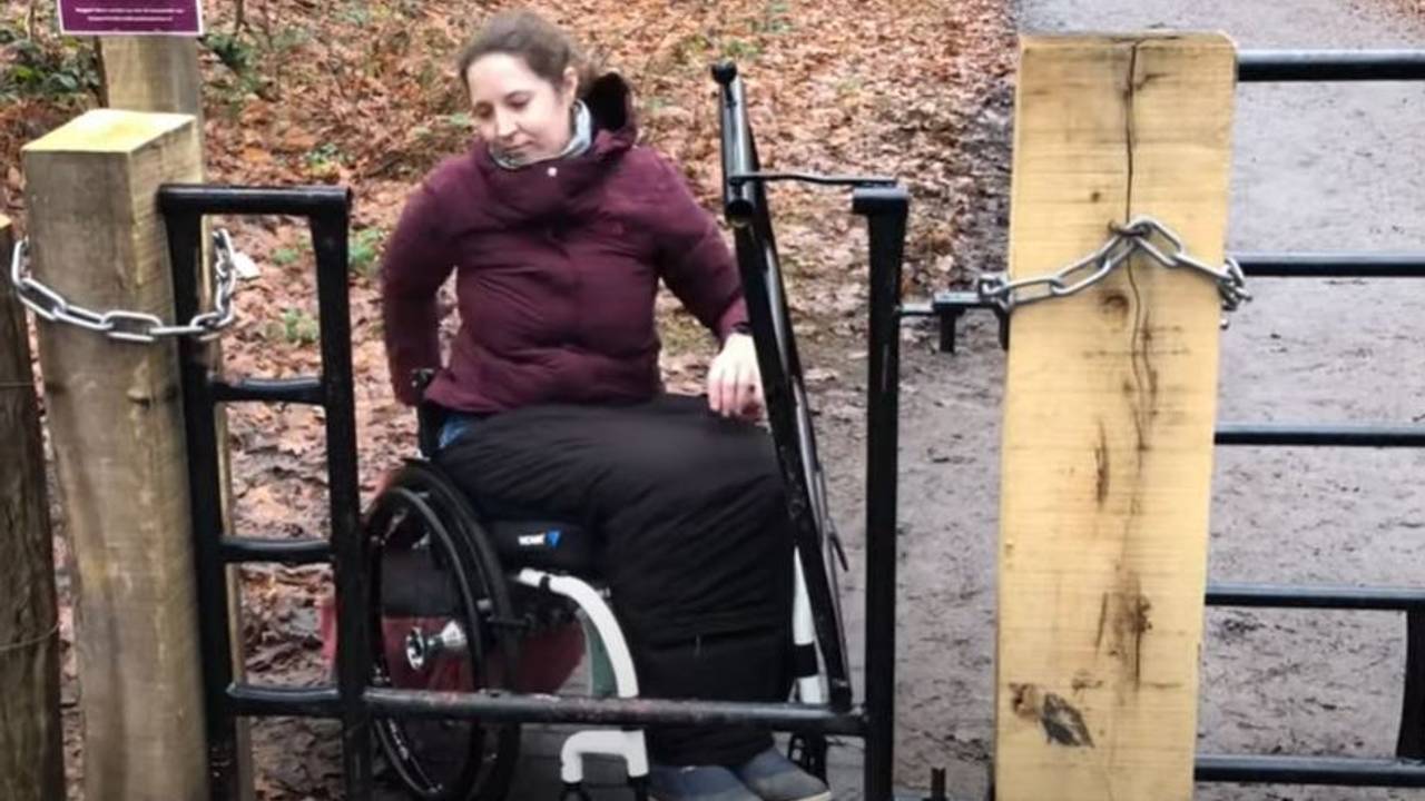 Sylke kan het bos bij Dorst niet meer in door een rolstoelonvriendelijk hek. Foto: Screenshot YouTube