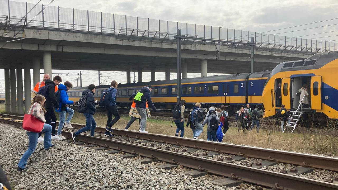 Passagiers worden geëvacueerd naar een andere trein.