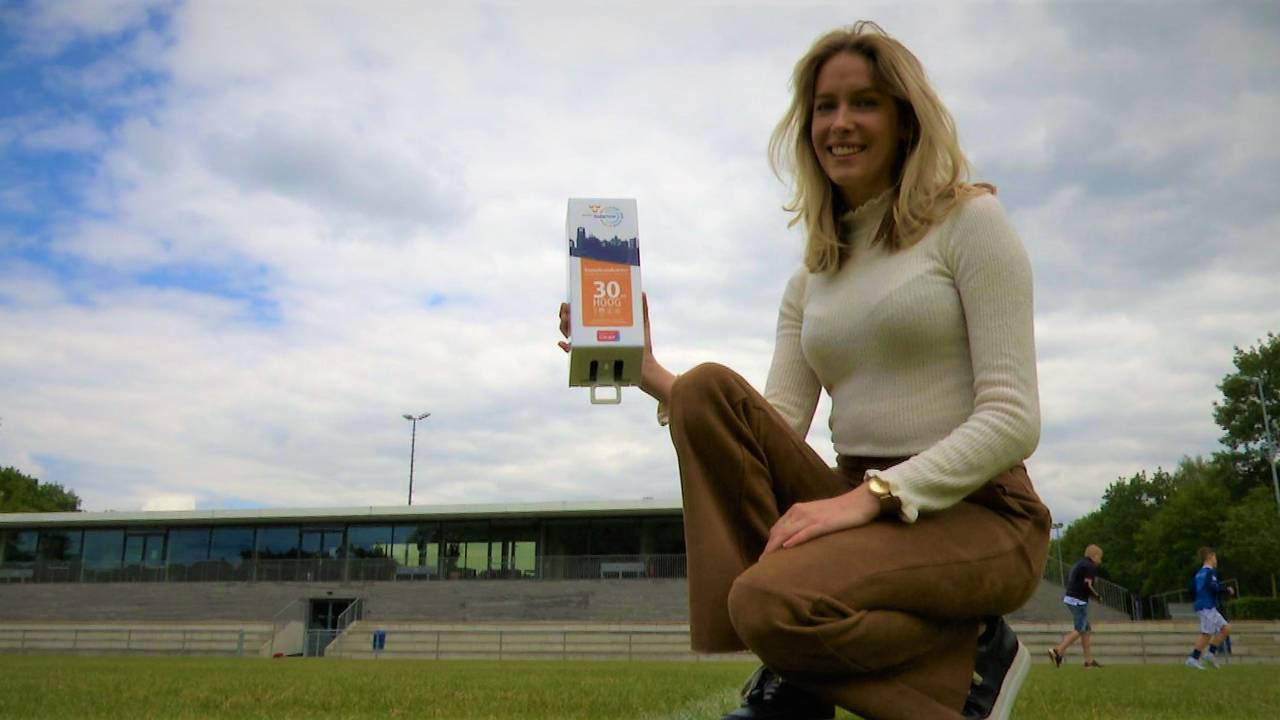 Lynn van Gils met een dispenser voor gratis zonnebrandcreme. (foto: Raoul Cartens)