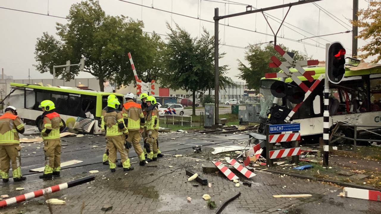 Bus doormidden na botsing met trein, ravage enorm.