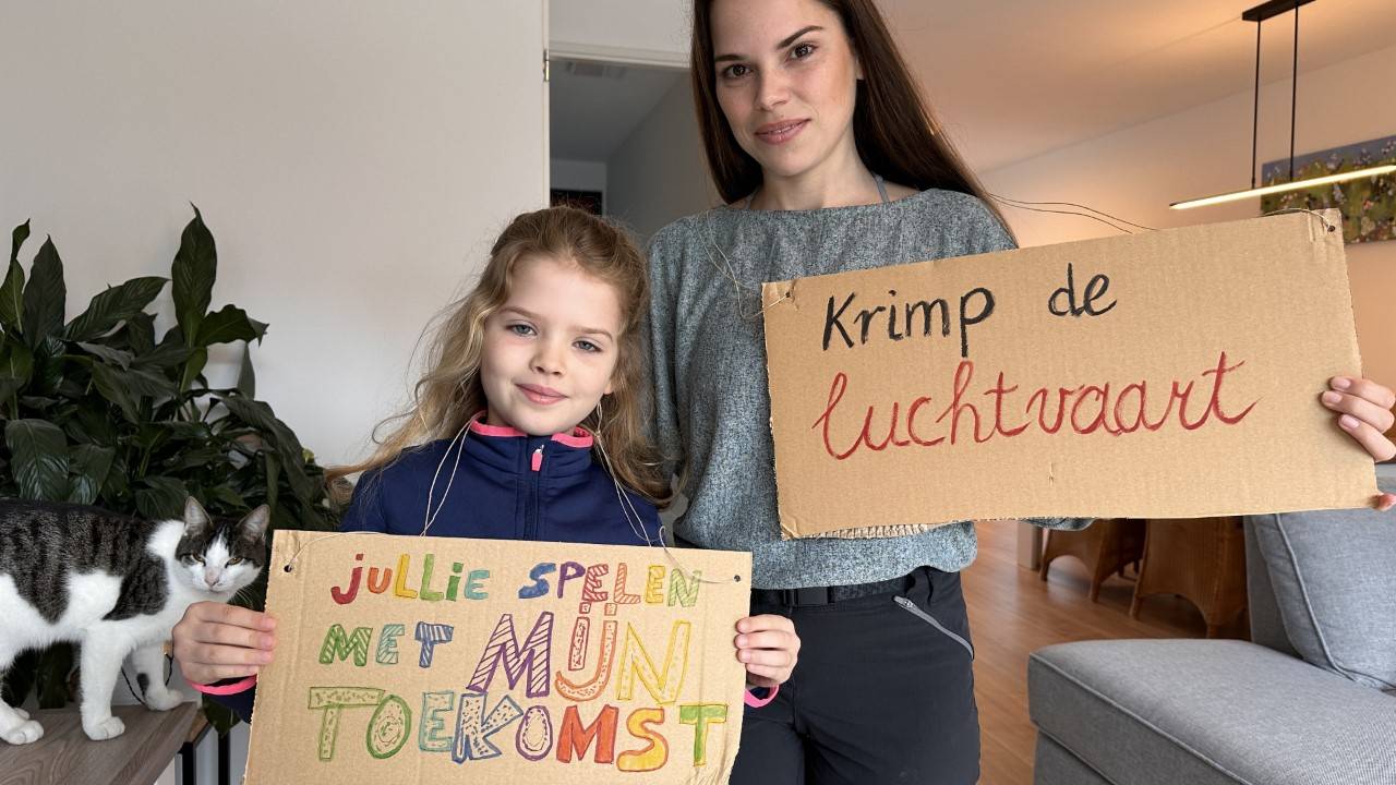 Eva (7) en haar moeder Stefanie met hun zelfgemaakte protest borden (foto: Jan Peels)