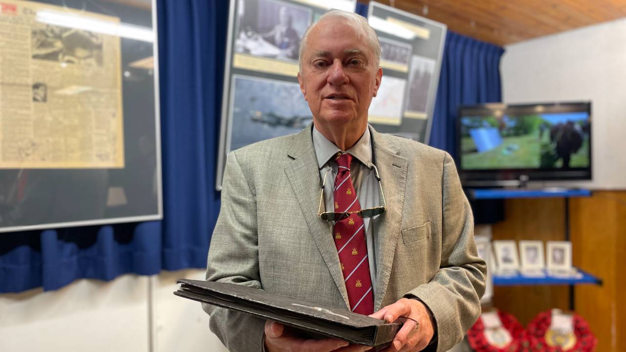 Lewis Burpee (79) met het fotoalbum.