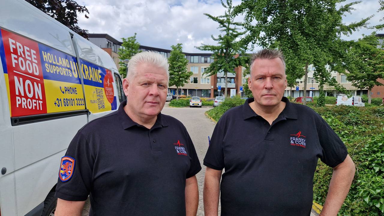 Franky en Coen naast hun bus, die bij de raketinslag aan alle kanten ontwricht raakte (Foto: Noël van Hooft).