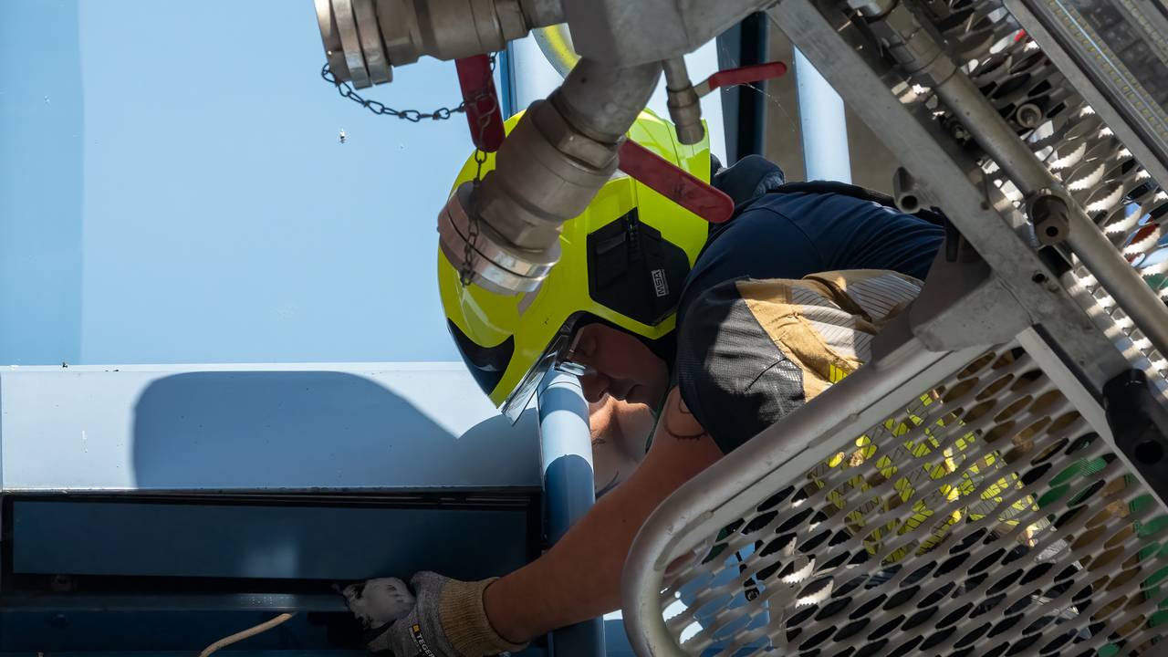 Een brandweerman redt de duif uit zijn benarde positie (foto: Iwan van Dun/SQ Vision).