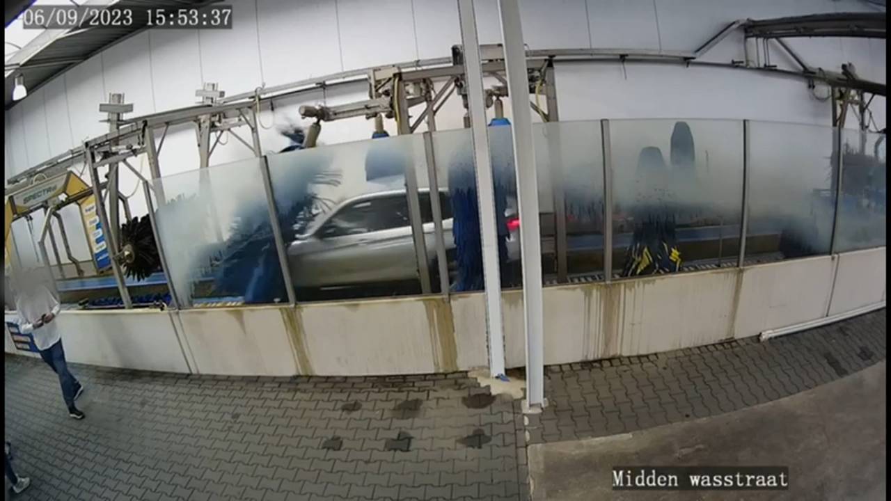 Camerabeeld van de auto die door de wasstraat raast.
