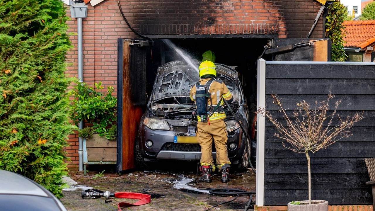 De brandweer blust een garagebrand in Sleeuwijk. (foto Jurgen Versteeg / SQ Vision) 