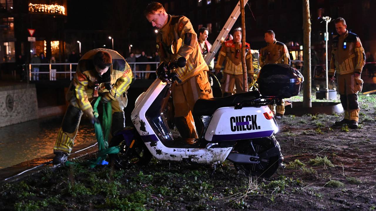 Brandweerlieden visten de scooter uit het water. 