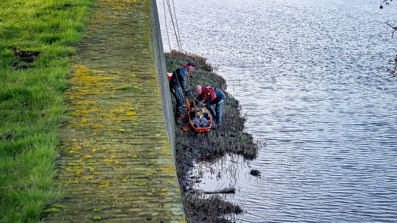 De man is door de brandweer op een brancard gelegd en naar boven getakeld (foto: Iwan van Dun/SQ Vision).