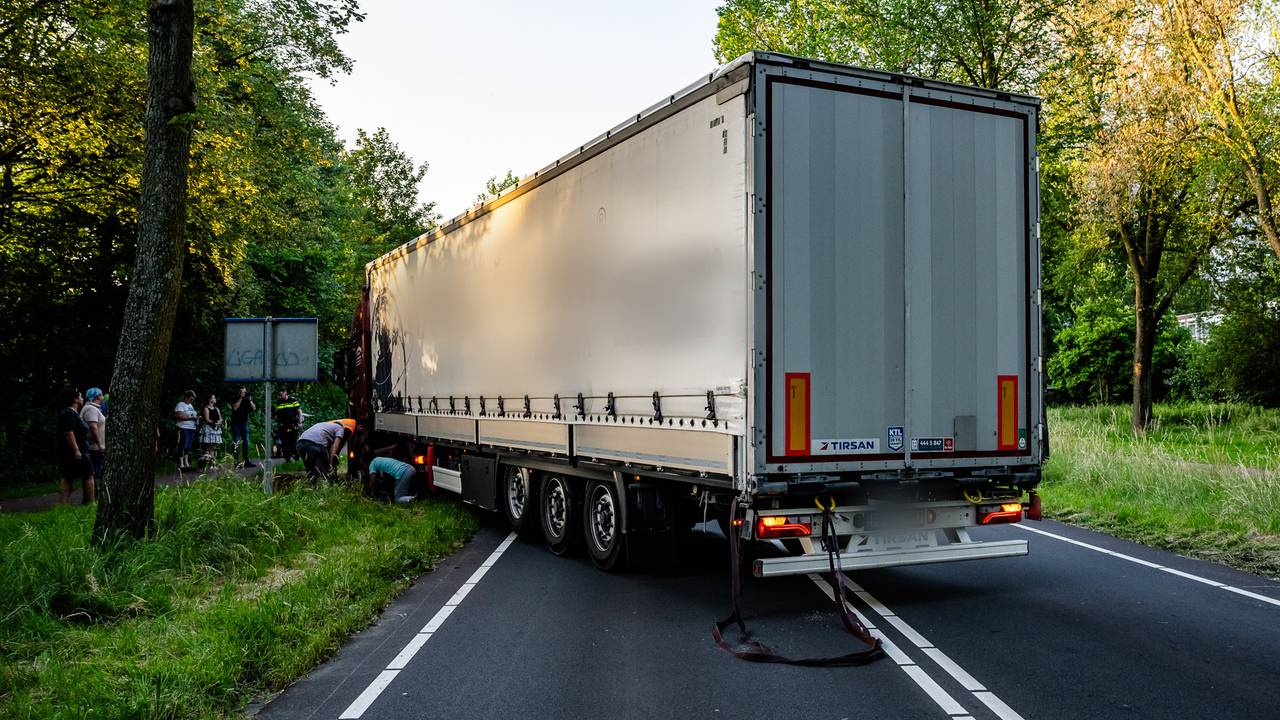 Bergingsmedewerkers proberen de vrachtauto los te trekken (foto: SQ Vision/Jack Brekelmans).