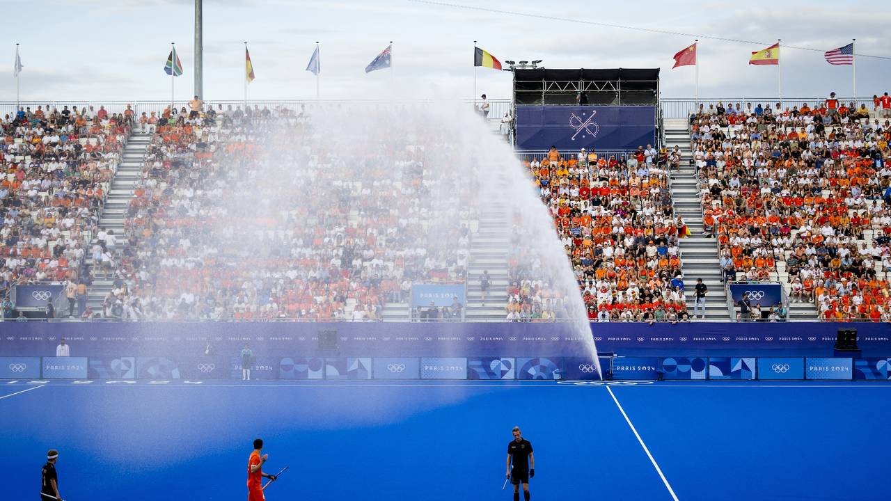 De sproeier bij het hockeyveld sprong tijdens de mannenfinale ineens aan (foto: ANP/Remko de Waal).