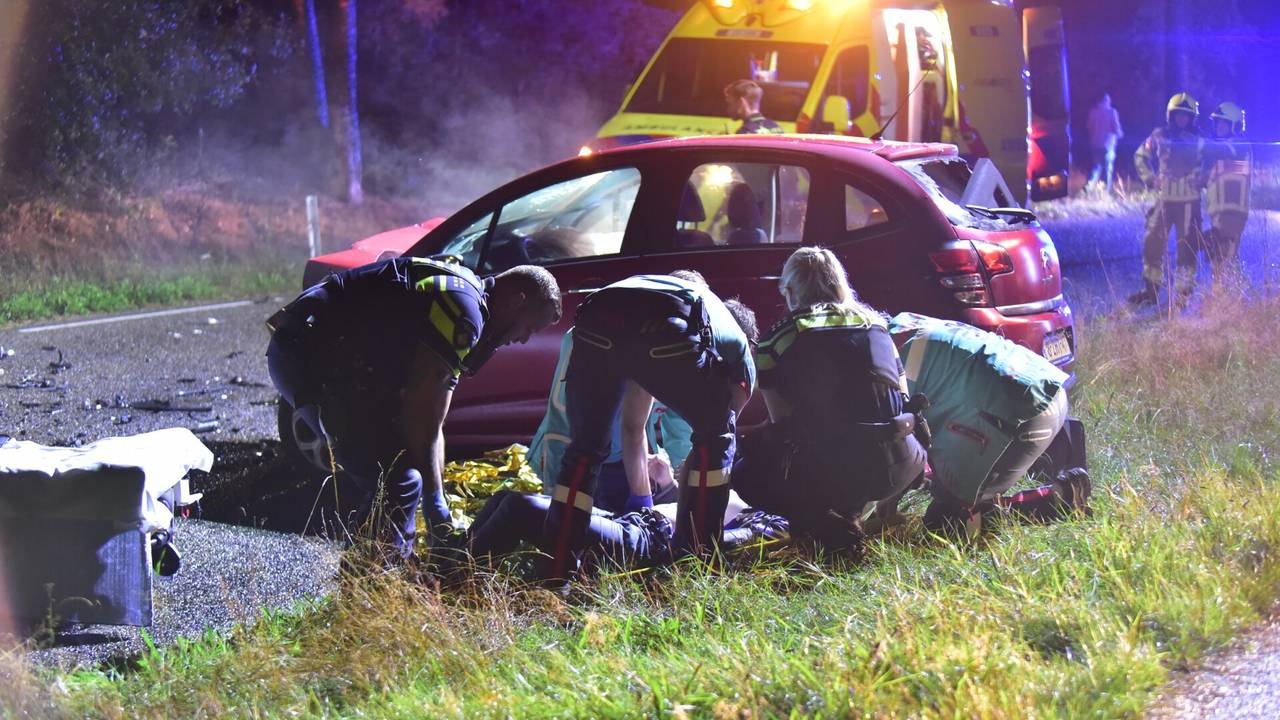 Twee personen zwaargewond bij frontale botsing, weg bezaaid met brokstukken.