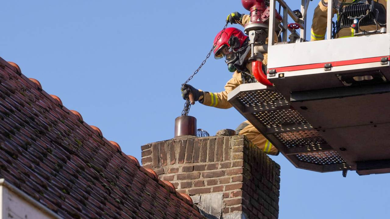 De brandweer maakt de schoorsteen schoon, nadat het vuur was geblust (foto: Harrie Grijseels/SQ Vision)