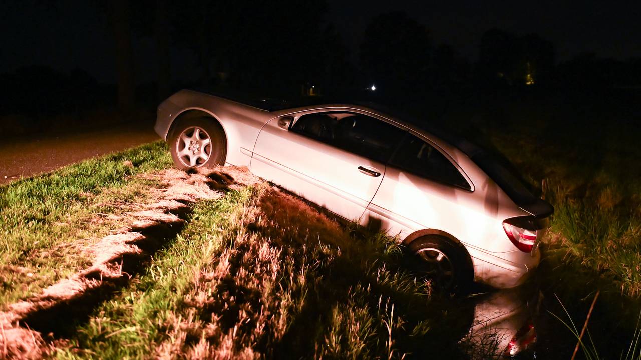 De auto hangt in de sloot langs een van de buitenwegen van Liessel (foto: Walter van Bussel/SQ Vison)