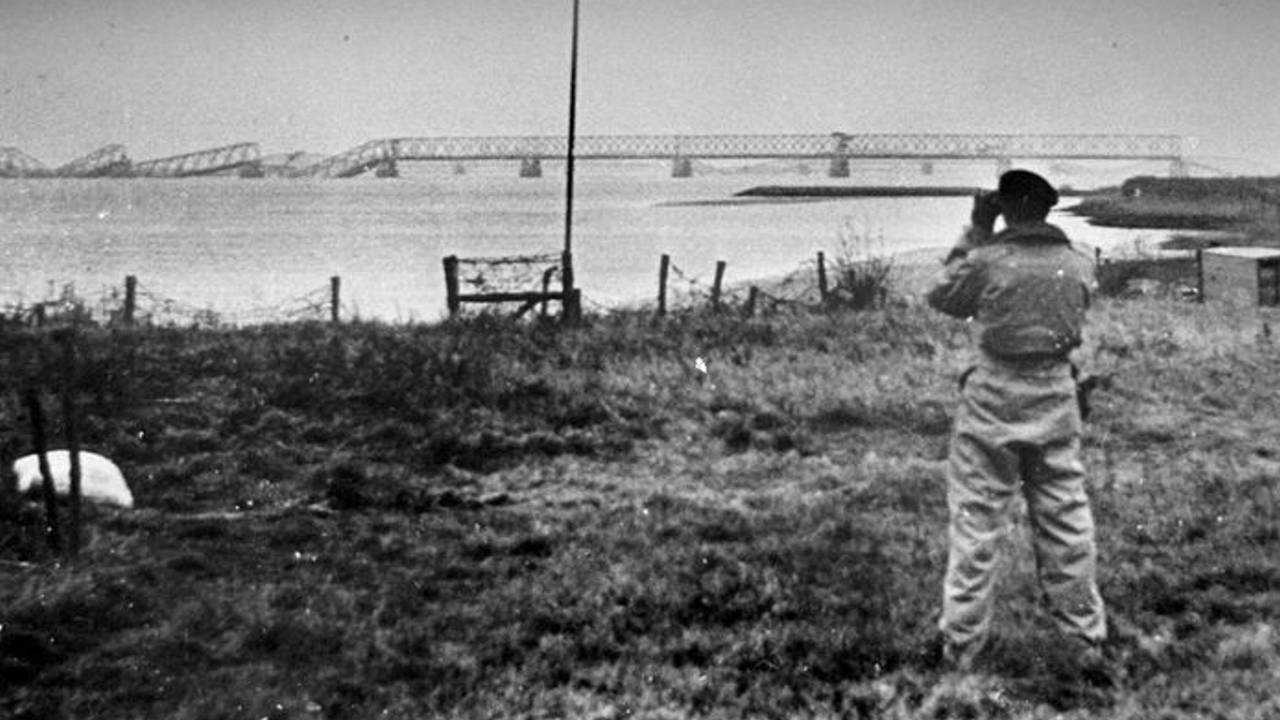 Poolse militair tuurt met verrekijker naar de kapotte Moerdijkbrug (foto: archief)