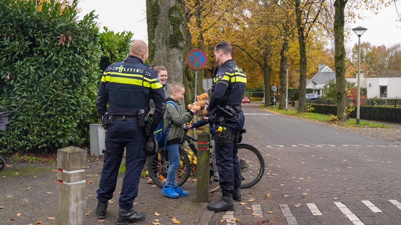 De politie geeft kinderen een knuffelbeer als troost (foto: Harrie Grijseels/SQ Vision).
