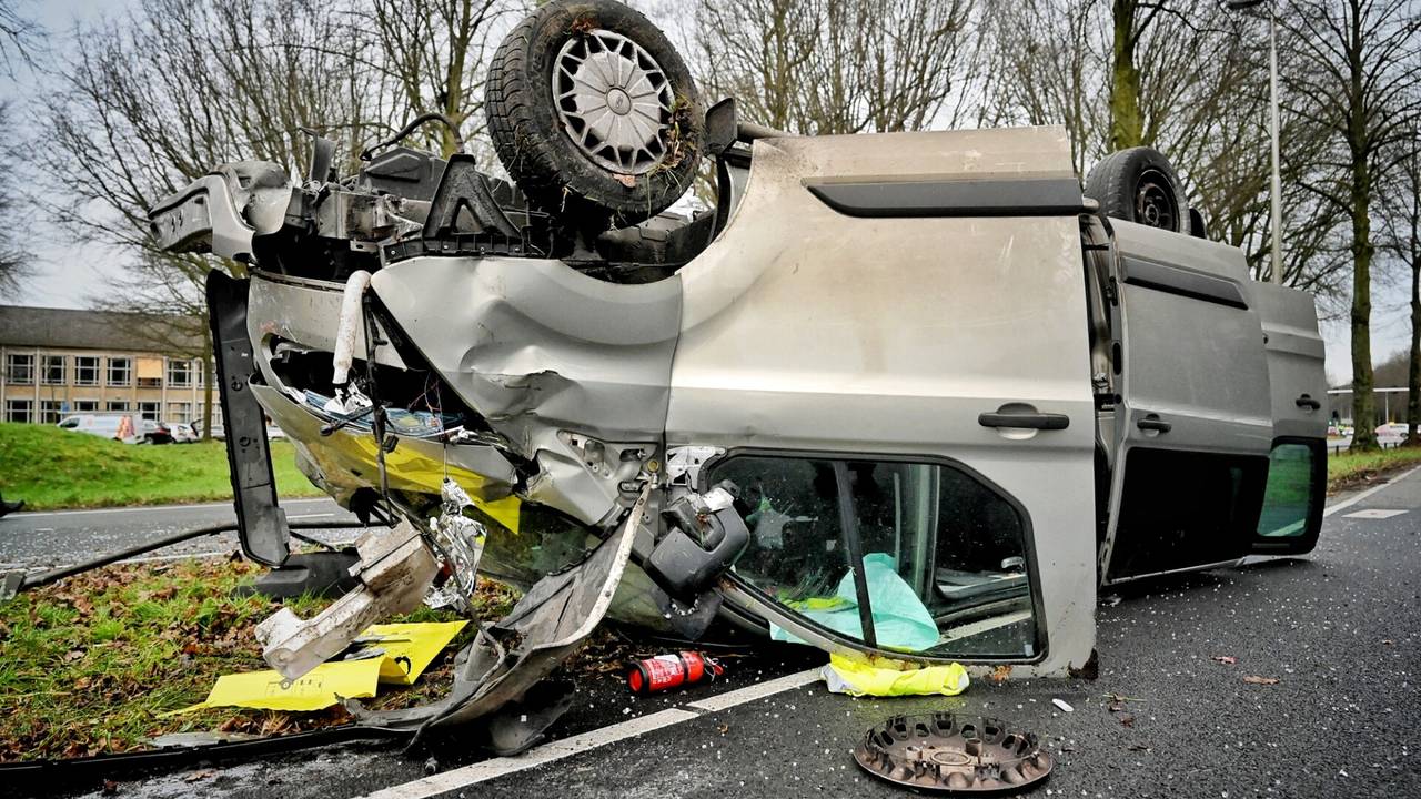 Auto belandt op kop bij ongeluk, weg bezaaid met brokstukken.
