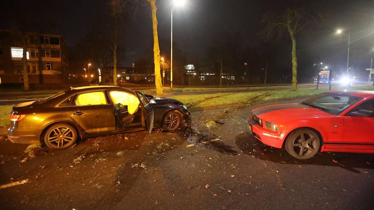 Twee gewonden na botsing, ambulance rijdt zich vast in modderige berm.